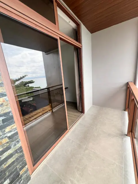 Wood-framed windows and private balcony
